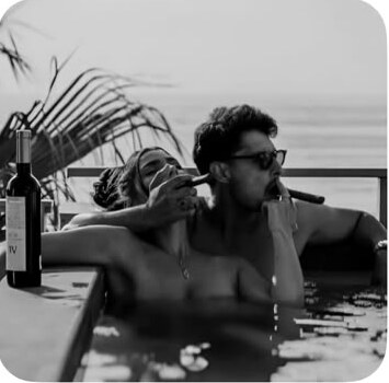 Pareja brindando en una piscina en blanco y negro