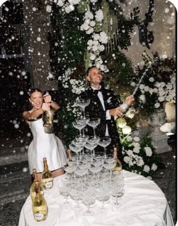 Pareja brindando junto a una torre de copas